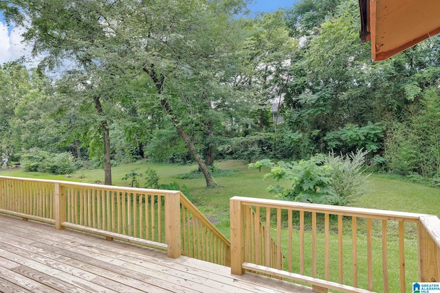 wooden terrace featuring a lawn