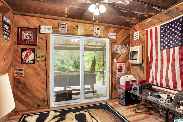 doorway to outside featuring a wall mounted AC, wood walls, ceiling fan, and hardwood / wood-style flooring