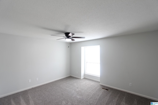 empty room with ceiling fan, carpet, and a textured ceiling