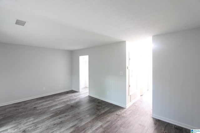 unfurnished room featuring dark wood-type flooring