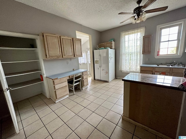 kitchen with ceiling fan, a textured ceiling, white refrigerator with ice dispenser, sink, and light tile floors