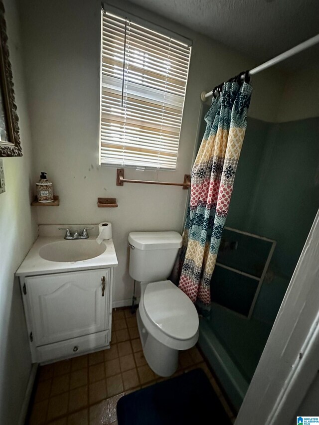 bathroom with tile floors, toilet, and large vanity