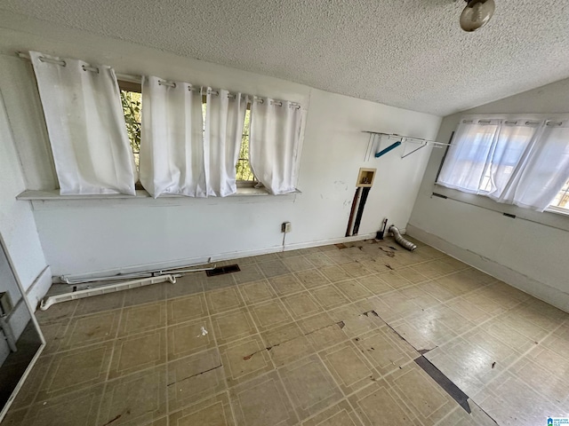 unfurnished room with a textured ceiling and tile flooring