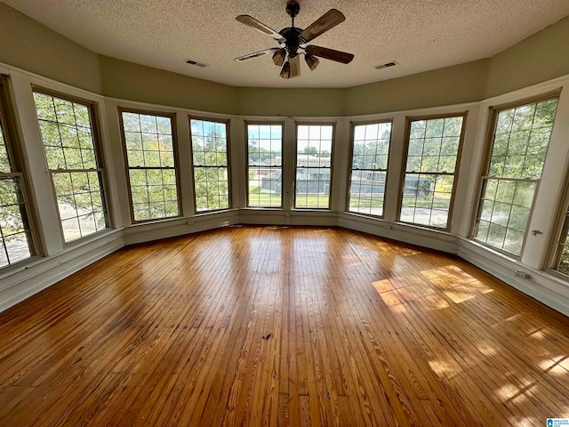 unfurnished sunroom with plenty of natural light and ceiling fan