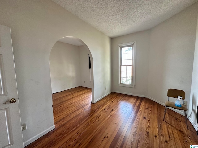 spare room with wood-type flooring and a textured ceiling