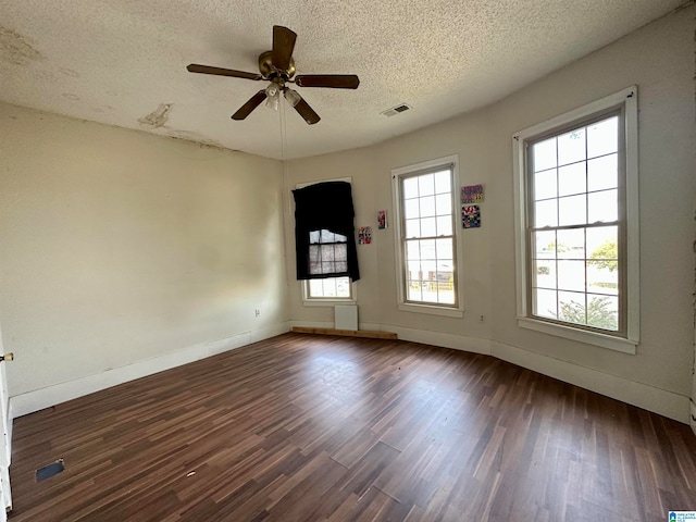 unfurnished room with ceiling fan, dark hardwood / wood-style floors, and a textured ceiling