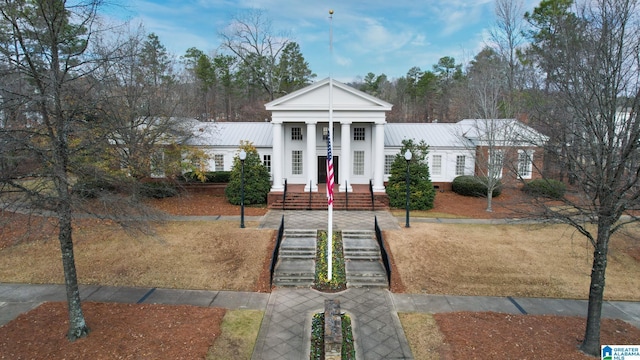 greek revival inspired property with a front lawn