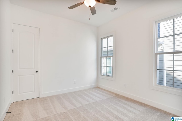 carpeted spare room featuring ceiling fan