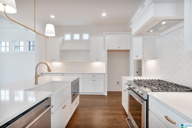 kitchen featuring stainless steel appliances, white cabinetry, custom range hood, and pendant lighting