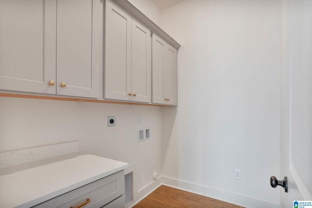 laundry room with cabinets, hookup for a washing machine, light hardwood / wood-style flooring, and electric dryer hookup