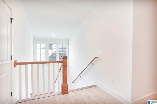 hall featuring baseboards, recessed lighting, and an upstairs landing