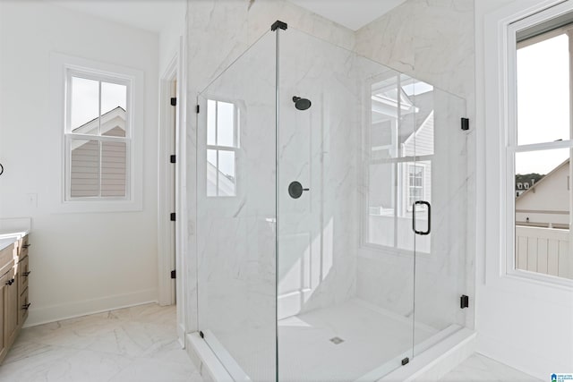 full bathroom featuring plenty of natural light, vanity, marble finish floor, and a marble finish shower
