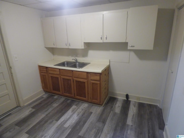 kitchen with sink, white cabinetry, and dark hardwood / wood-style floors