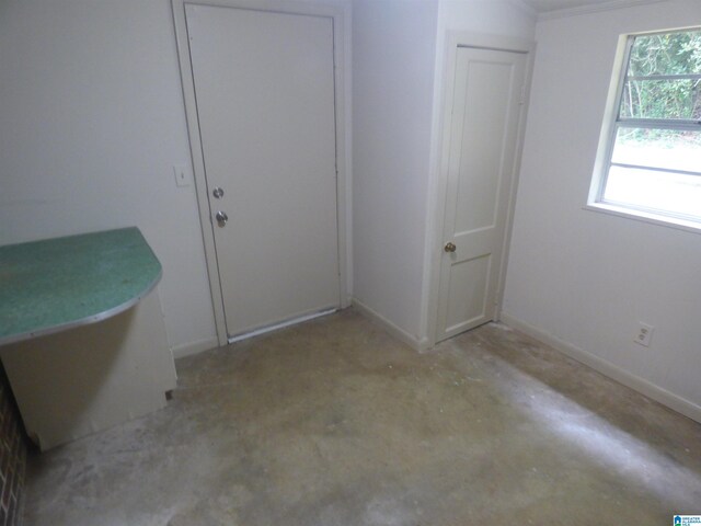 unfurnished bedroom with concrete floors and a closet