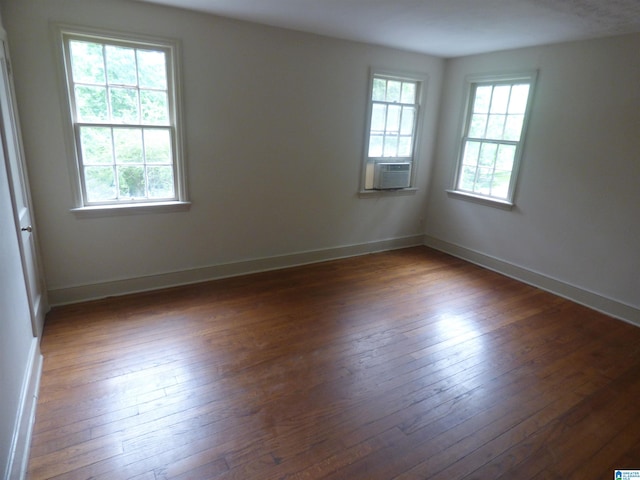 unfurnished room featuring dark hardwood / wood-style floors and a wealth of natural light
