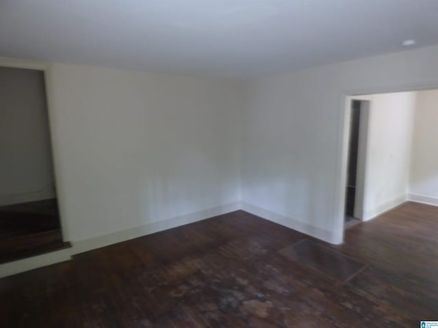 unfurnished room with dark hardwood / wood-style flooring