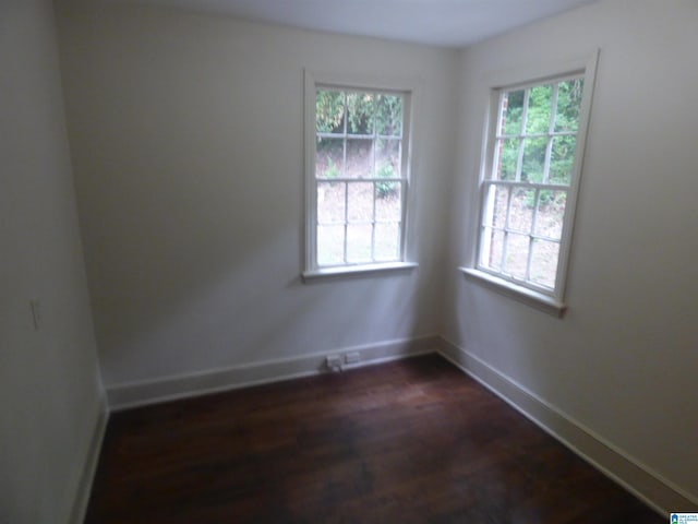 spare room with dark hardwood / wood-style floors and a healthy amount of sunlight