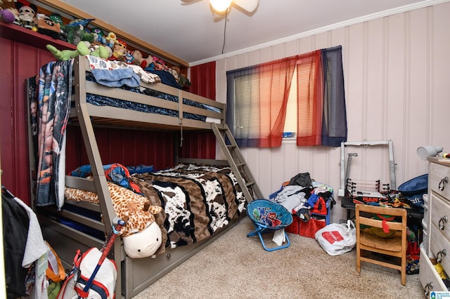 carpeted bedroom featuring a ceiling fan and crown molding