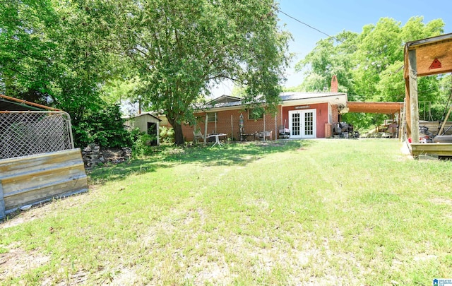 view of yard with an attached carport and french doors