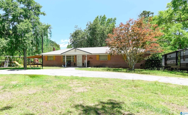 single story home featuring a front lawn, a playground, and brick siding