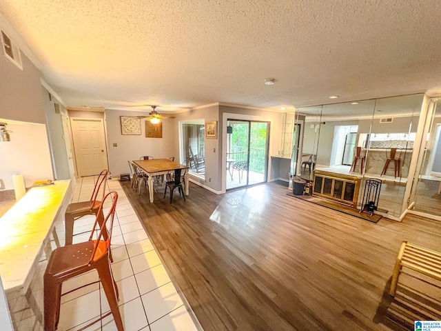 interior space featuring hardwood / wood-style flooring, ornamental molding, a textured ceiling, and ceiling fan