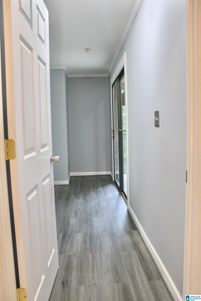 hallway with crown molding, a textured ceiling, and hardwood / wood-style floors