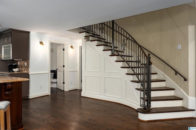 stairs with dark hardwood / wood-style flooring