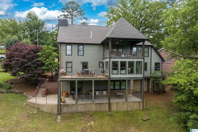 rear view of property featuring a yard, a patio area, and a balcony