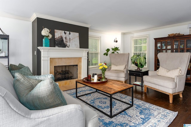 living room with crown molding, hardwood / wood-style flooring, and a tile fireplace