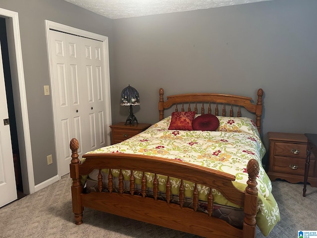 bedroom with a textured ceiling, carpet flooring, and a closet