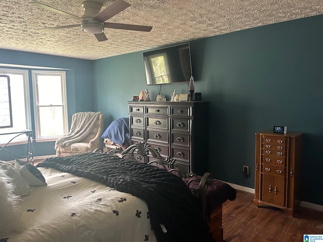 bedroom featuring dark wood-type flooring, ceiling fan, and a textured ceiling