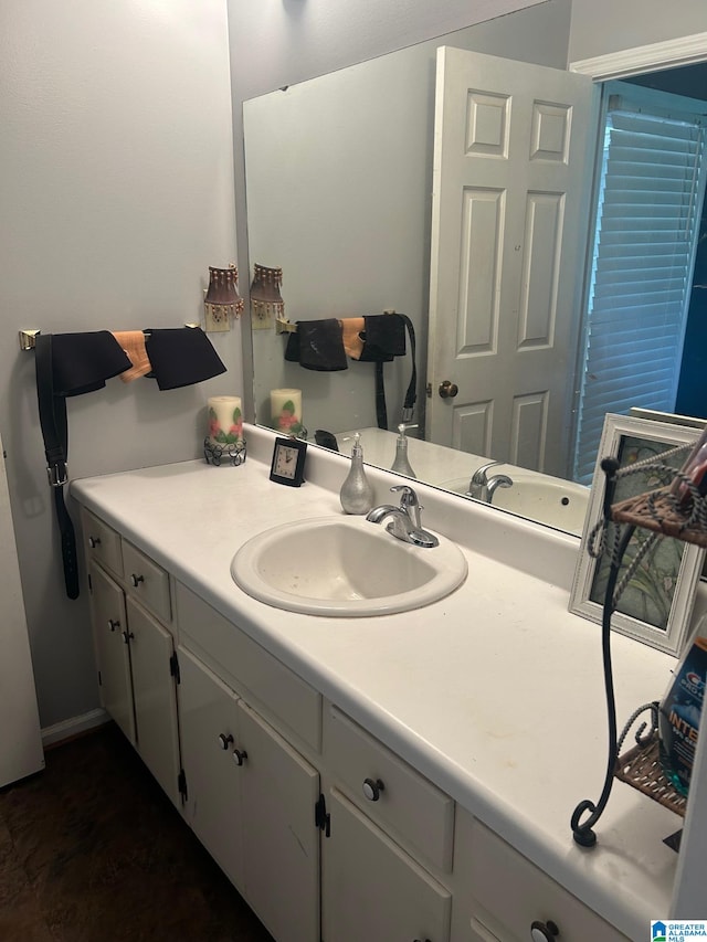 bathroom with hardwood / wood-style flooring and vanity with extensive cabinet space