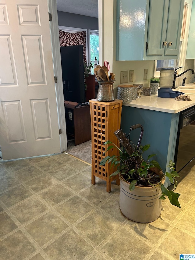 kitchen with black dishwasher and light tile flooring