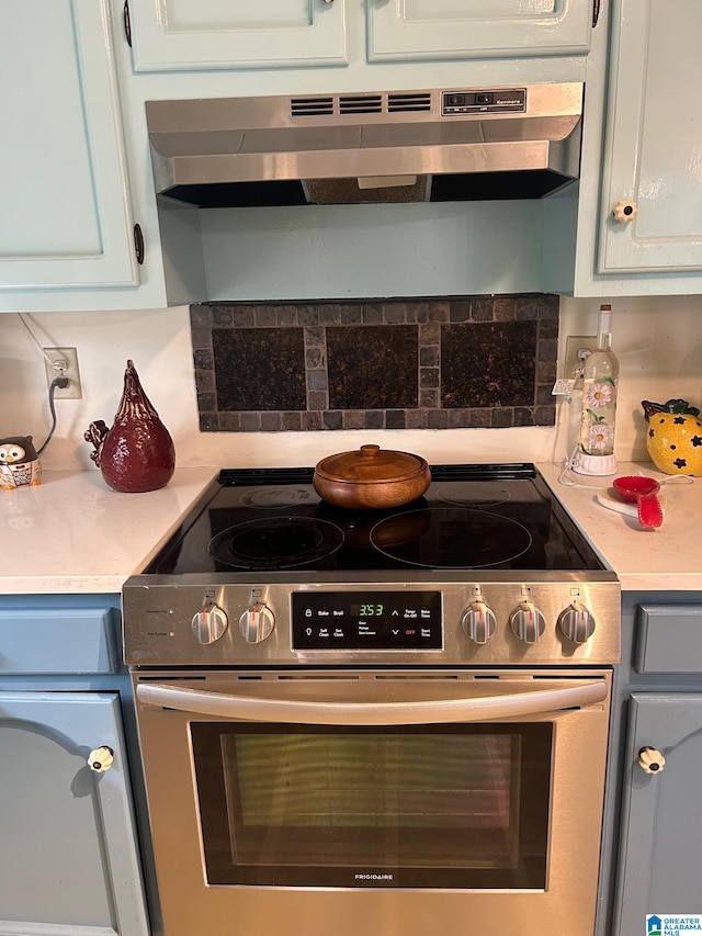 kitchen with wall chimney exhaust hood, stainless steel range with electric stovetop, and tasteful backsplash