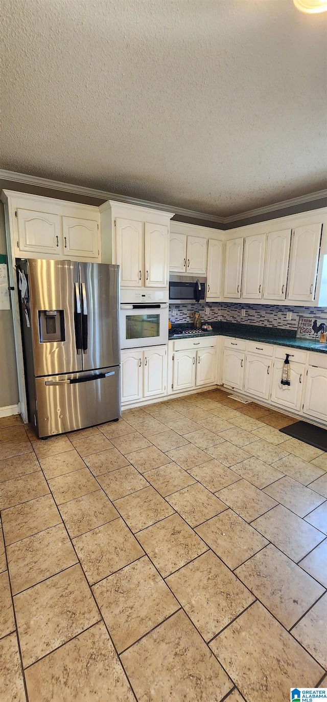 kitchen with white cabinetry, a textured ceiling, ornamental molding, stainless steel appliances, and backsplash