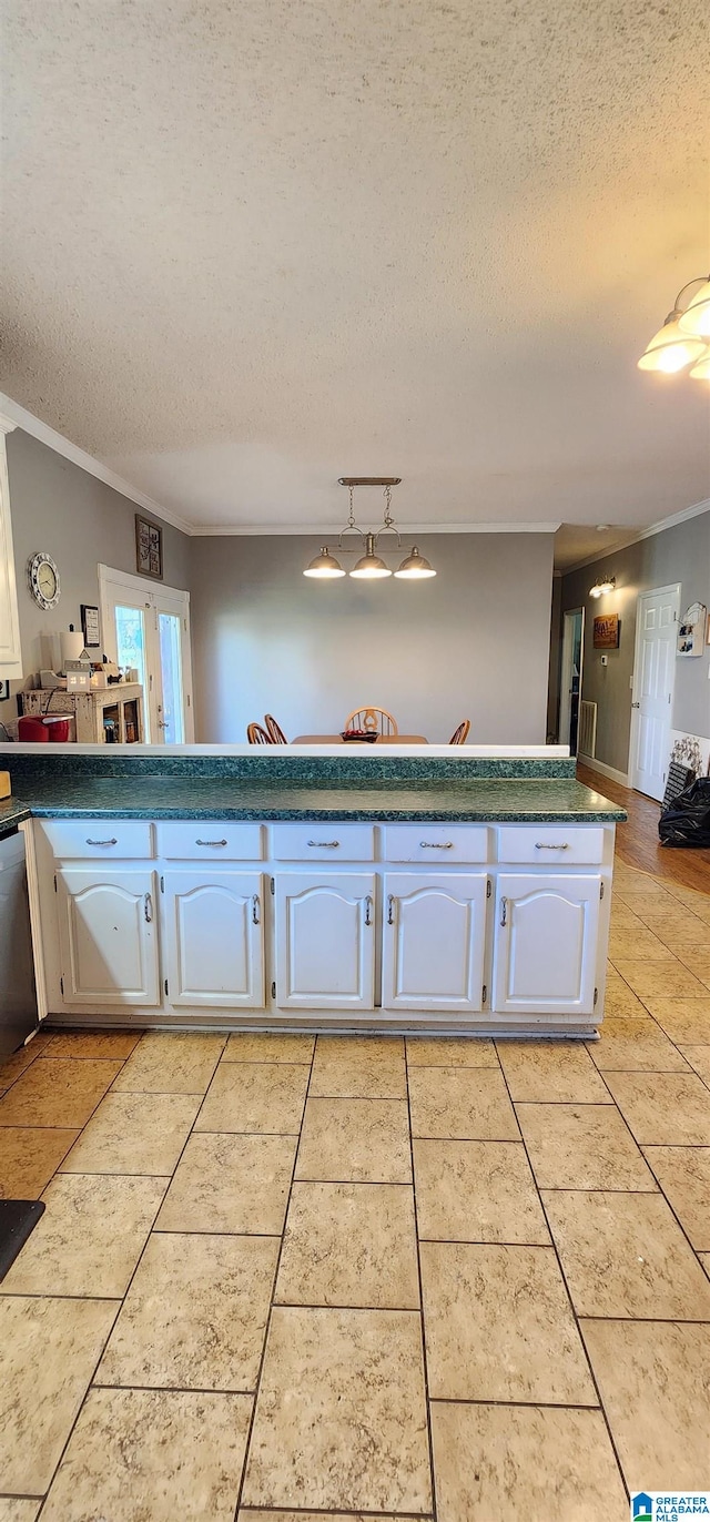 kitchen with a textured ceiling, ornamental molding, stainless steel dishwasher, white cabinets, and light tile floors