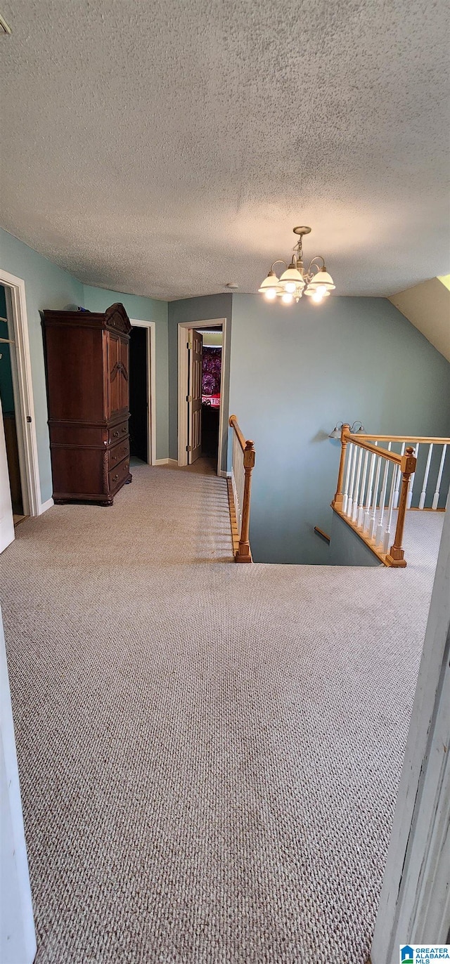 unfurnished bedroom featuring ceiling fan, carpet floors, a textured ceiling, and lofted ceiling