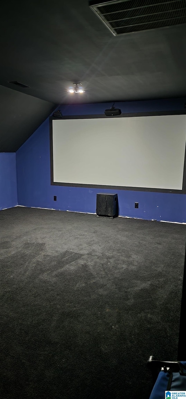 carpeted home theater with vaulted ceiling