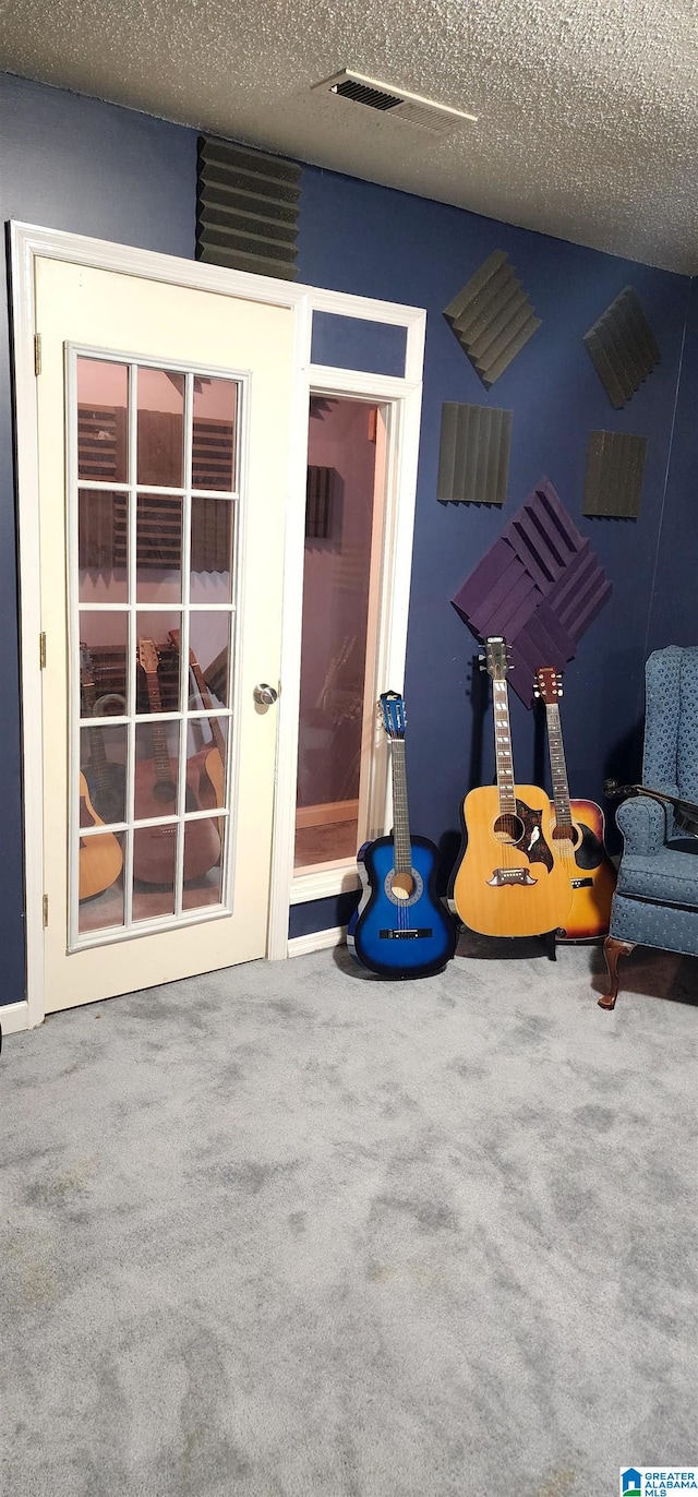 unfurnished room with a textured ceiling and carpet flooring