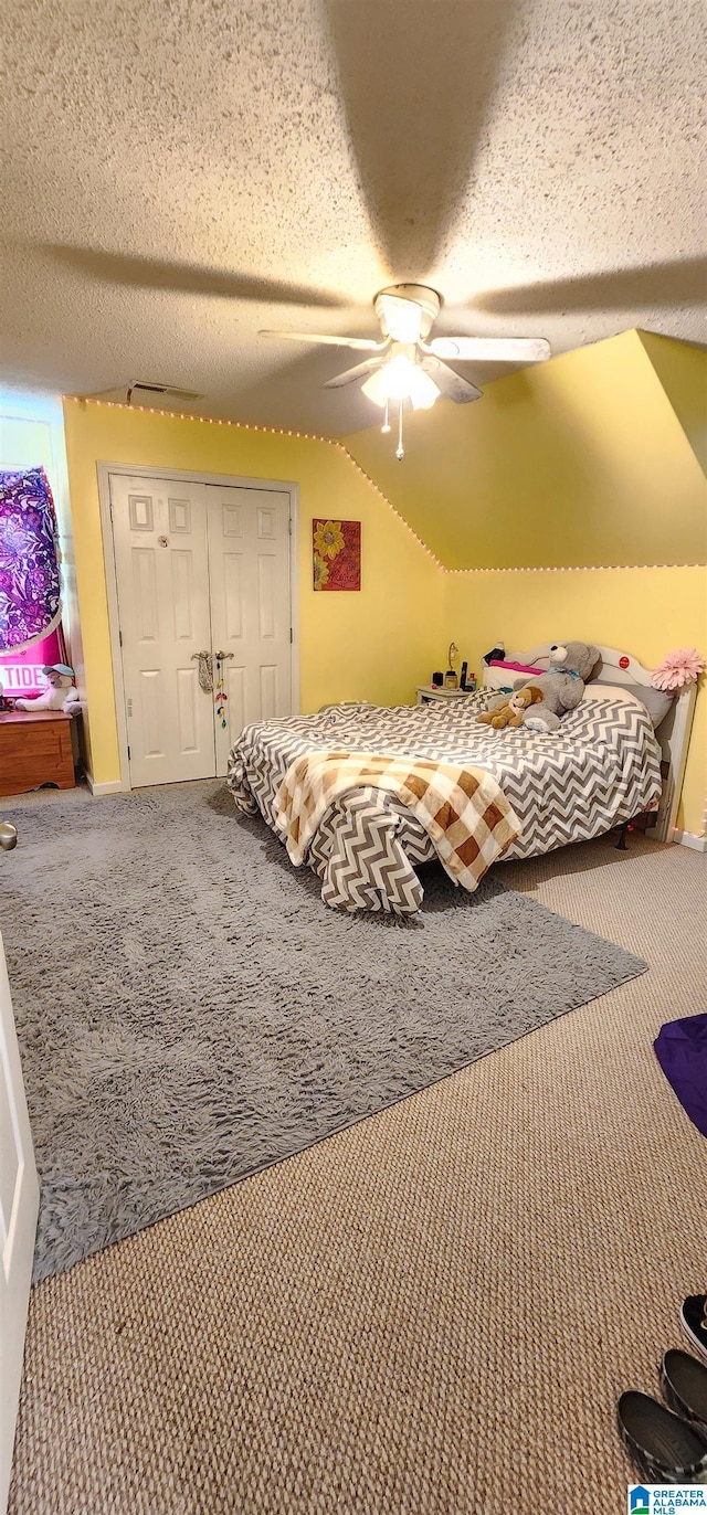 carpeted bedroom featuring a closet, ceiling fan, and a textured ceiling