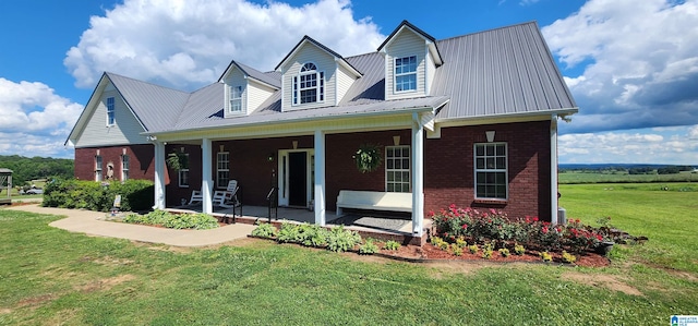 new england style home with a front yard and covered porch