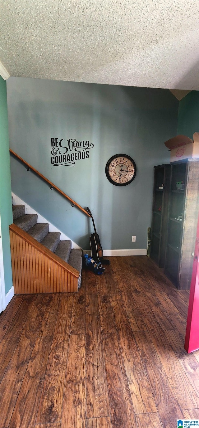 interior space featuring a textured ceiling and wood-type flooring