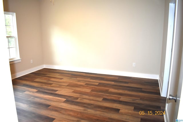 empty room featuring a healthy amount of sunlight and dark hardwood / wood-style flooring