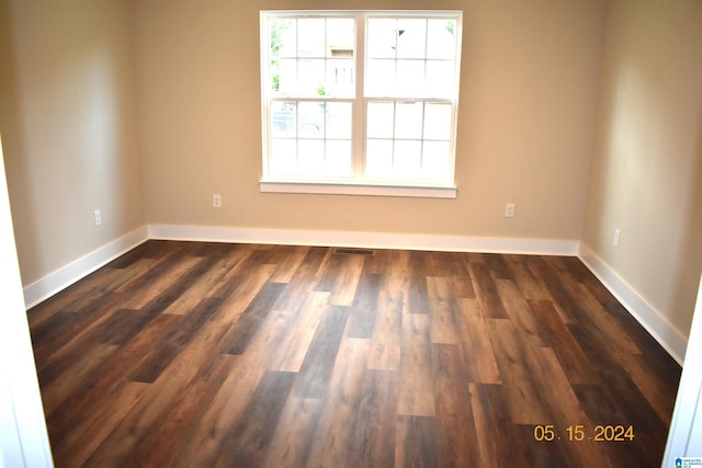 unfurnished room with dark wood-type flooring