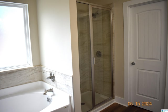 bathroom with plenty of natural light, wood-type flooring, and plus walk in shower