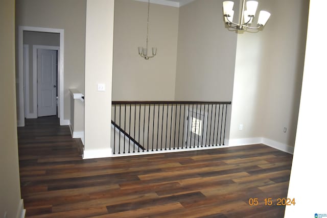 corridor featuring an inviting chandelier and dark hardwood / wood-style floors