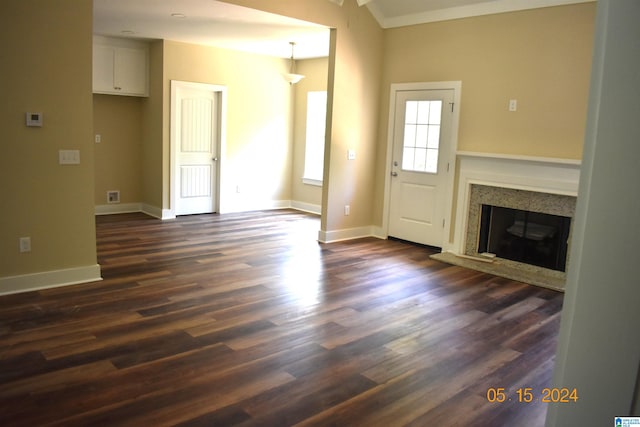 unfurnished living room featuring dark wood-type flooring and a high end fireplace