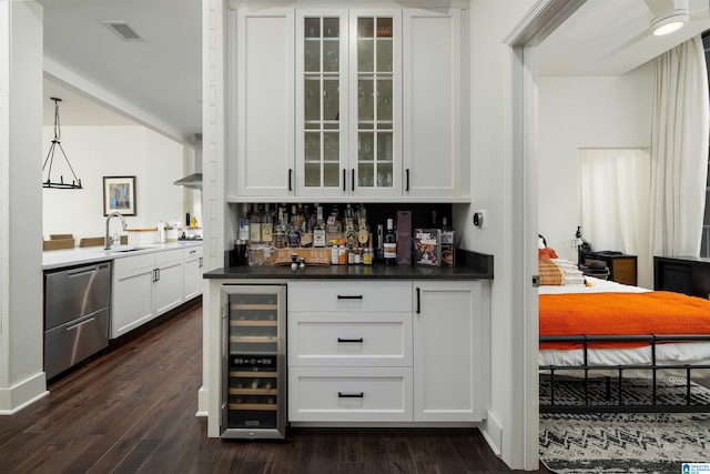 bar with wine cooler, dark hardwood / wood-style flooring, and white cabinets