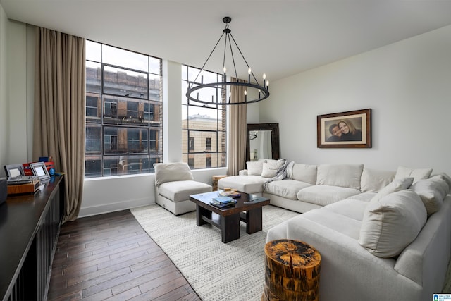 living room with a notable chandelier and dark wood-type flooring