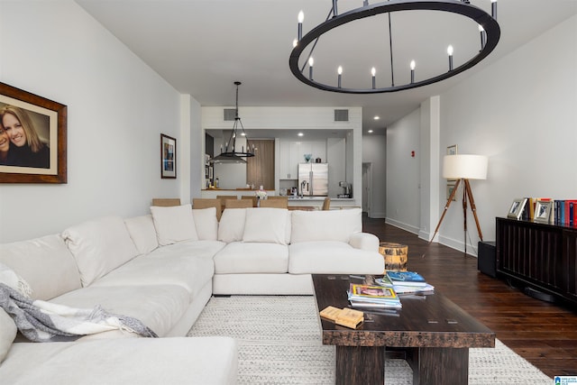 living room featuring a notable chandelier and dark wood-type flooring